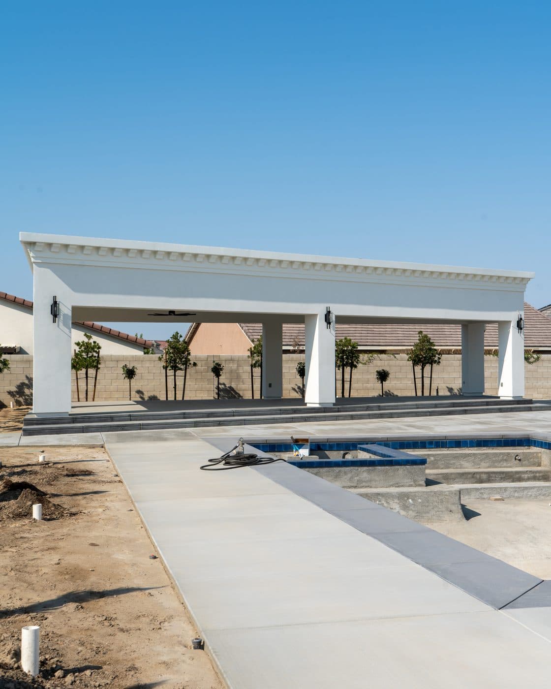 Completed white pavilion over a pool by Intrepid Plastering, Bakersfield